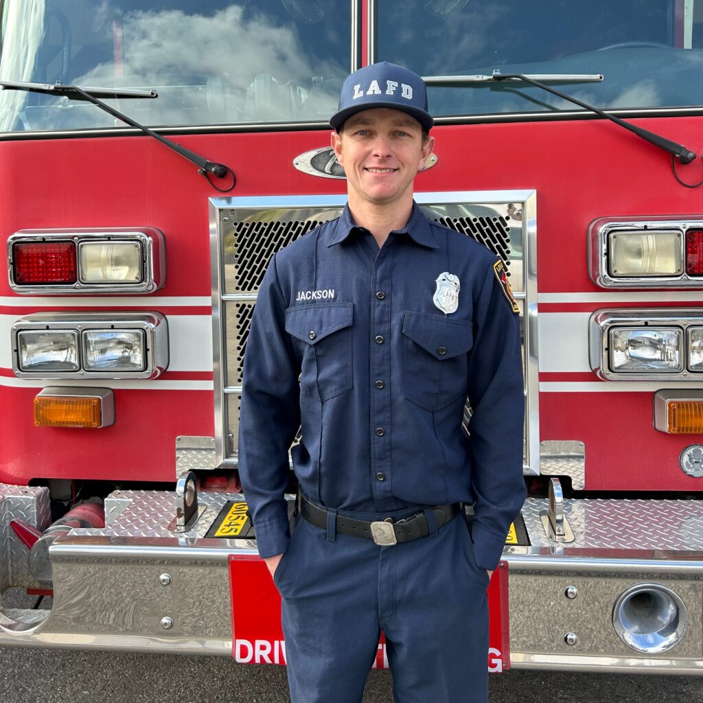 Apparatus Operator (AO) Robby Jackson poses in front of a LAFD fire truck.